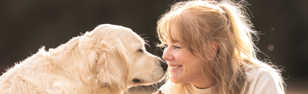 Hond kijkt vrouw heel liaf aan.